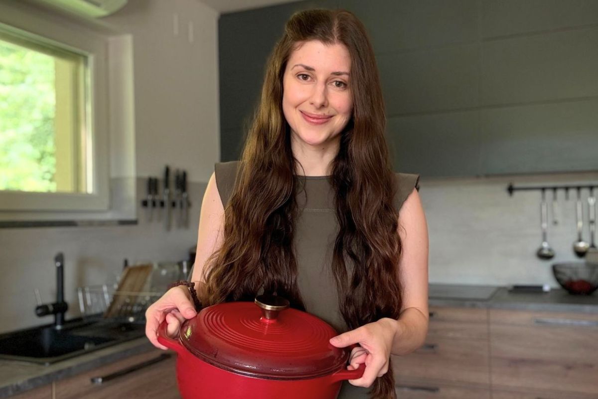 Freshly ground grain in a vibrant red cast iron pot for healthy baking and cooking. Perfect for homemade recipes.