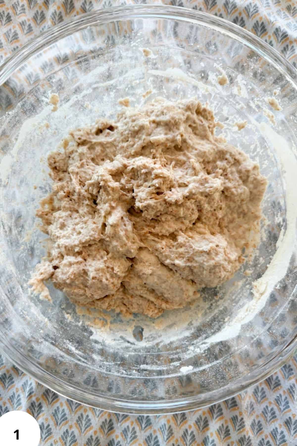 Freshly milled whole grain bread dough in a glass bowl for healthy baking recipes.