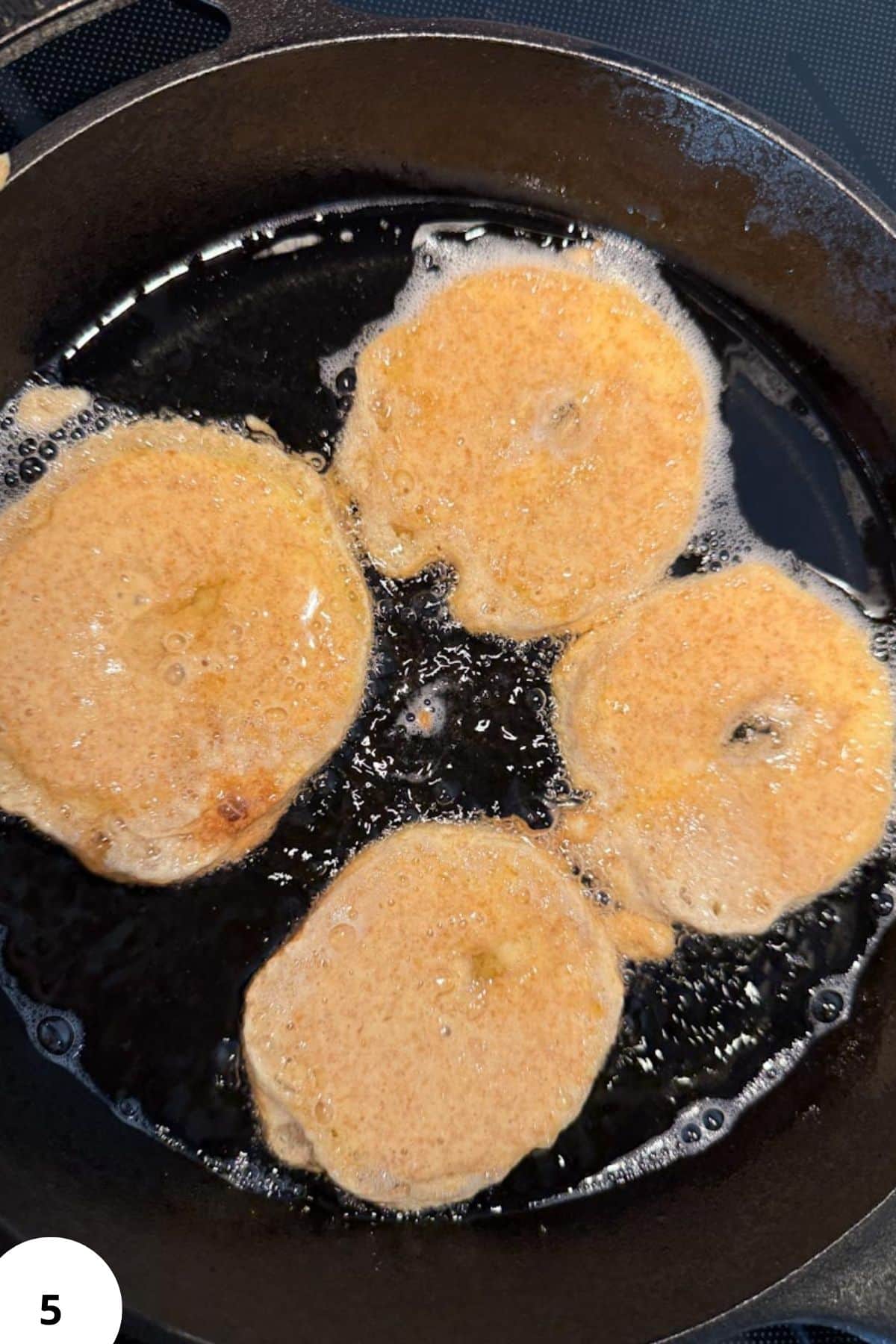 Fried plantains cooking in a skillet, showcasing golden exterior and crispy texture.