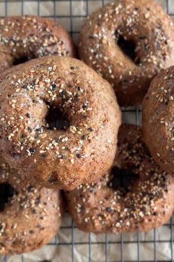 Delicious freshly baked whole grain bagels topped with seeds, oats, and herbs for a wholesome breakfast.