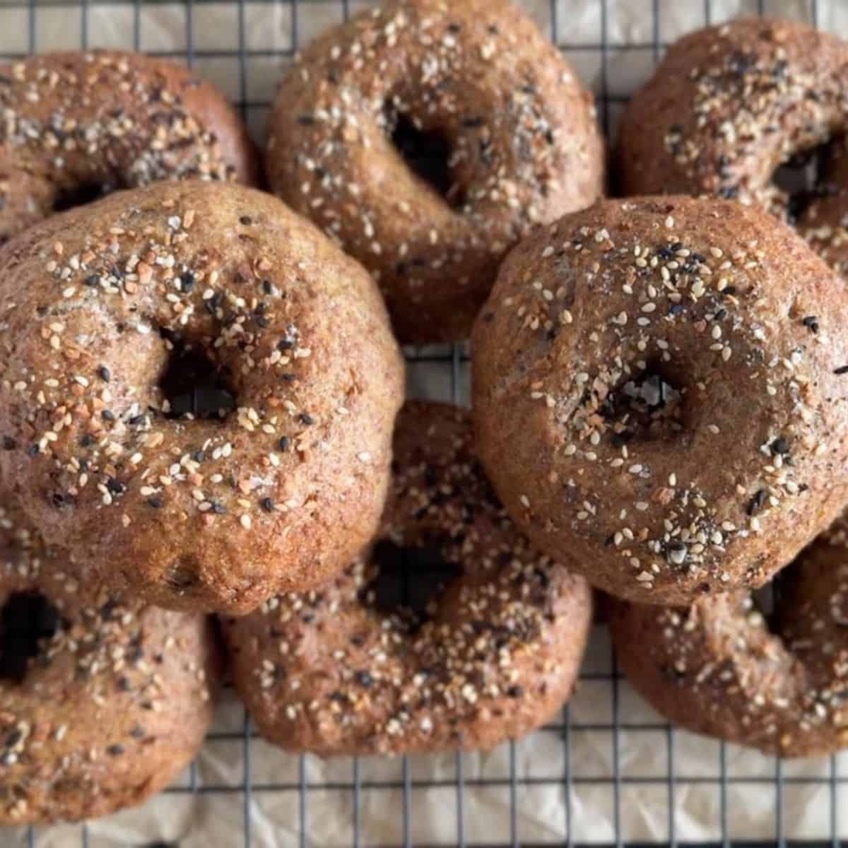 Delicious freshly baked whole grain bagels topped with seeds, oats, and herbs for a wholesome breakfast.