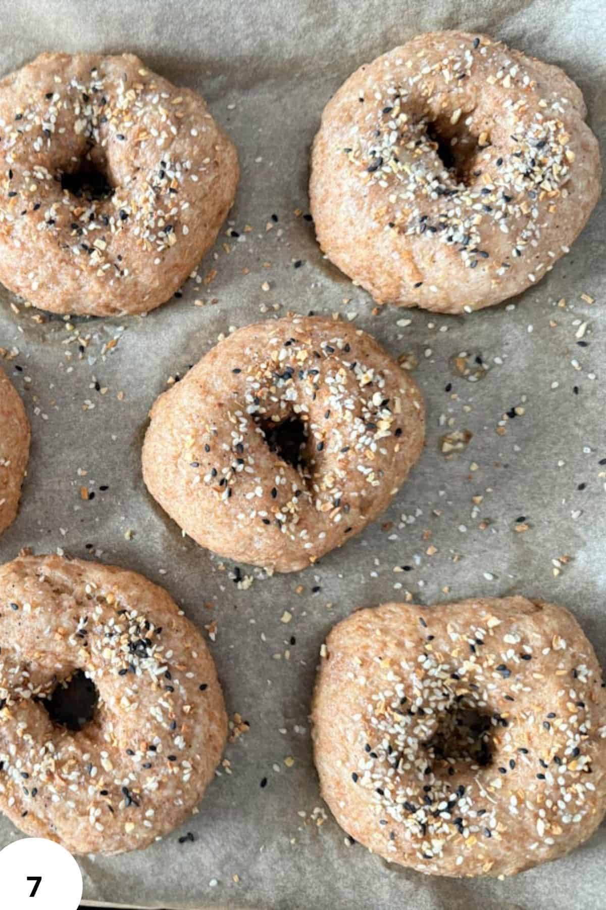 Freshly baked whole wheat bagels with a sprinkle of sesame and poppy seeds on top, made with freshly milled grains.