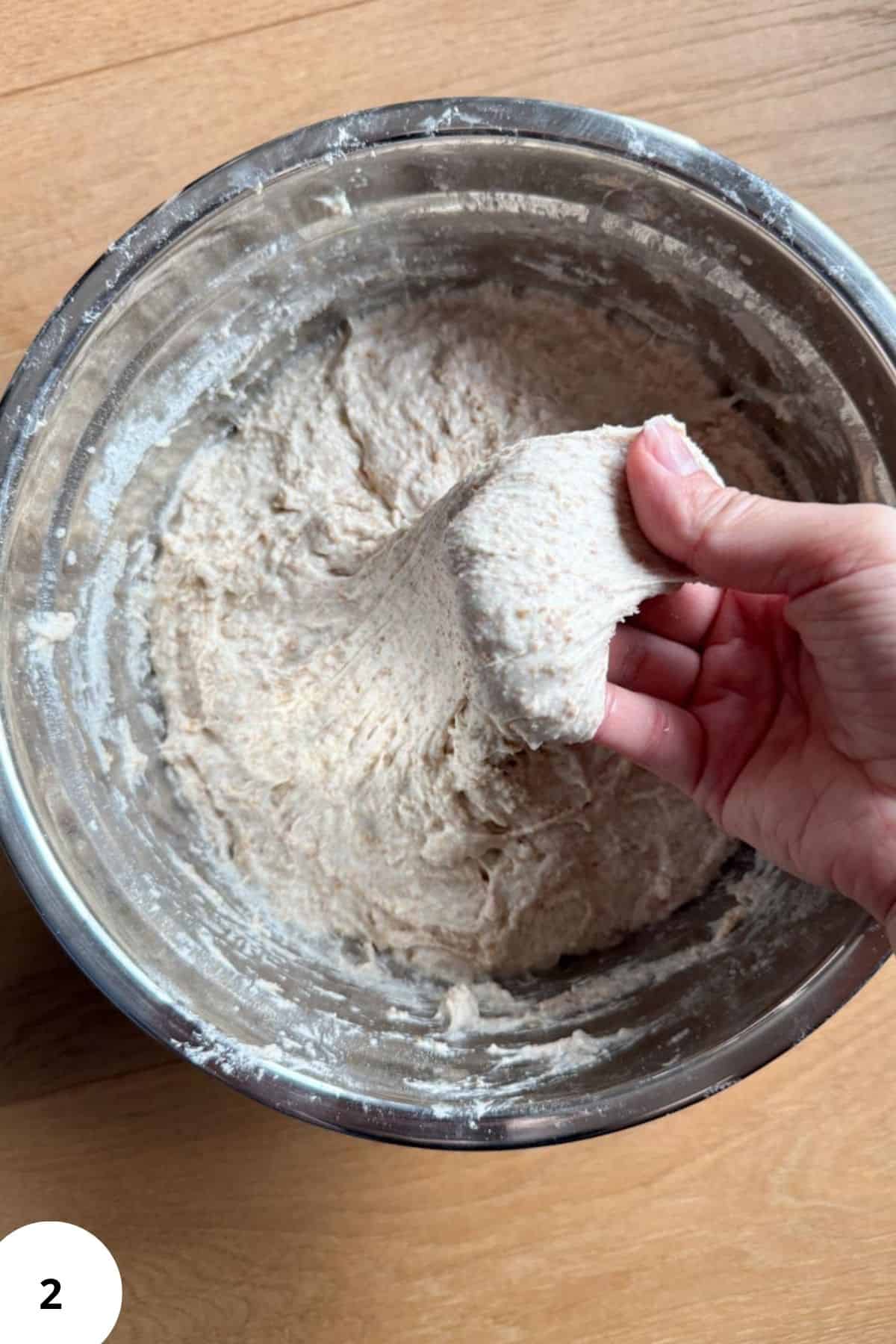 Bright, detailed image of bread dough being kneaded in bowl from fresh milled grains.