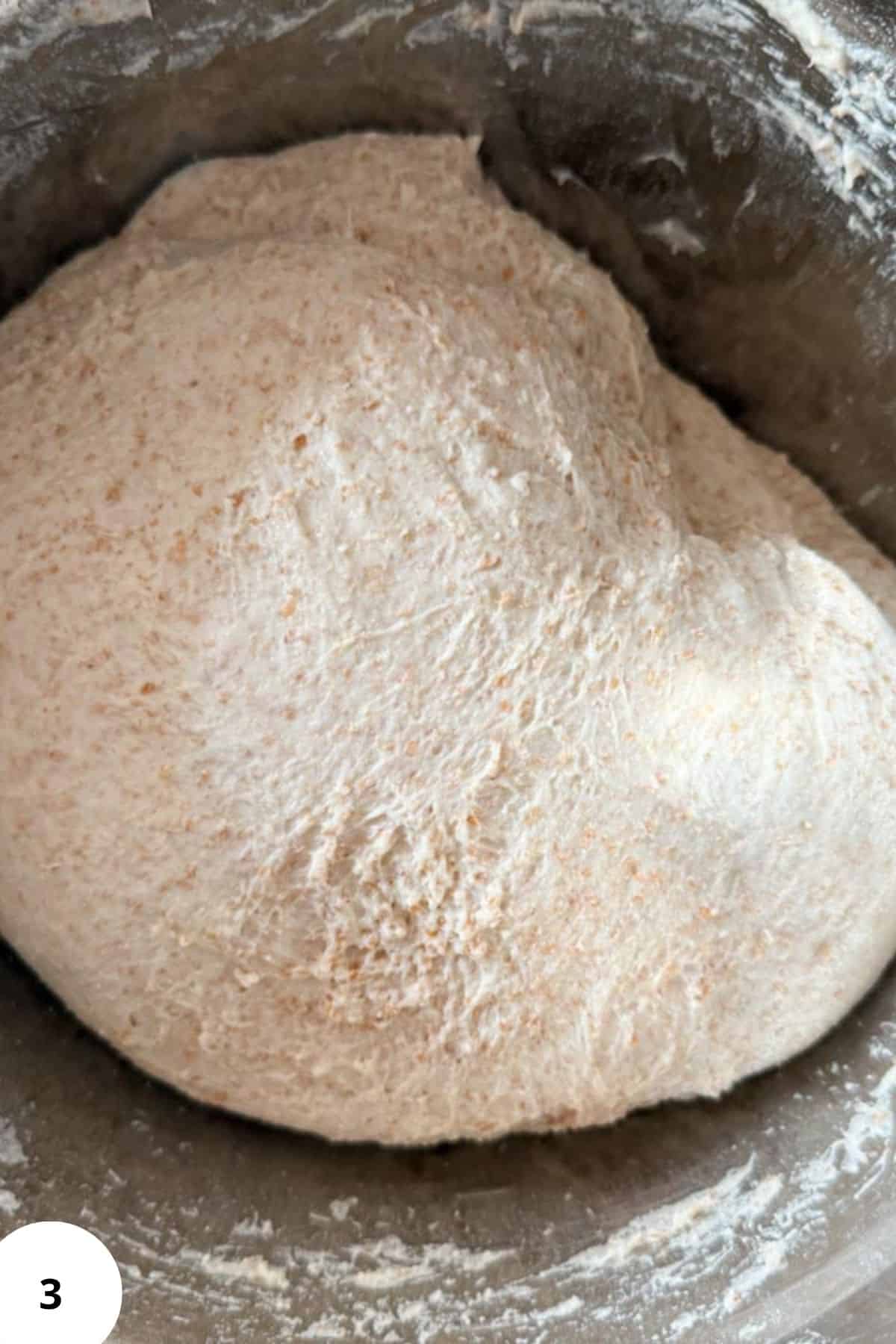 Fresh milled whole grain bread dough rising in a bowl, emphasizing healthy baking.