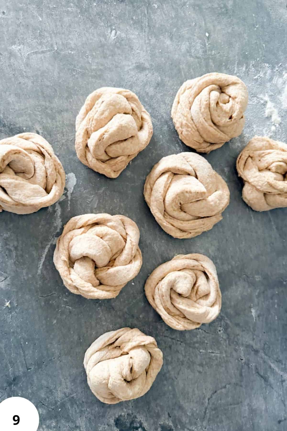 Freshly made dough knots for baking with whole grain flour. Perfect for healthy homemade bread and rolls.