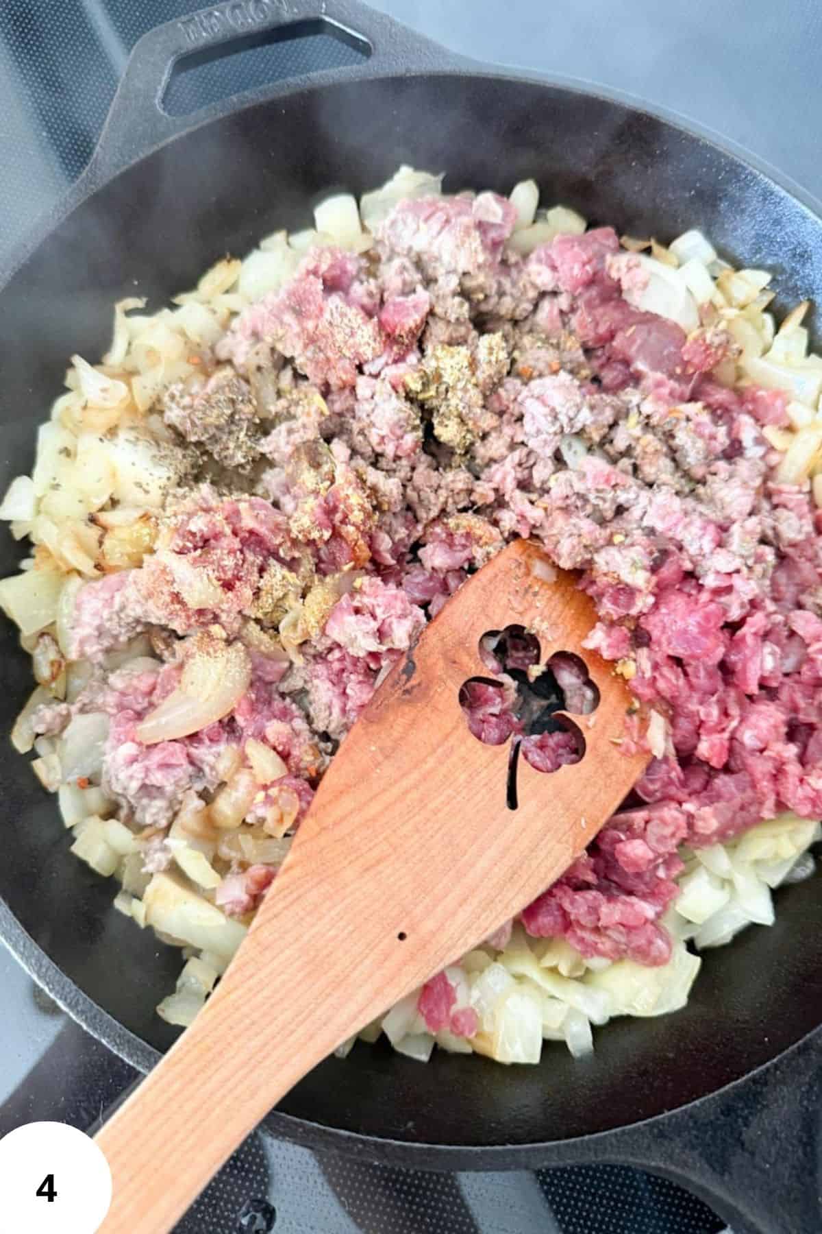 Minced beef and onions cook in skillet for hearty meal.