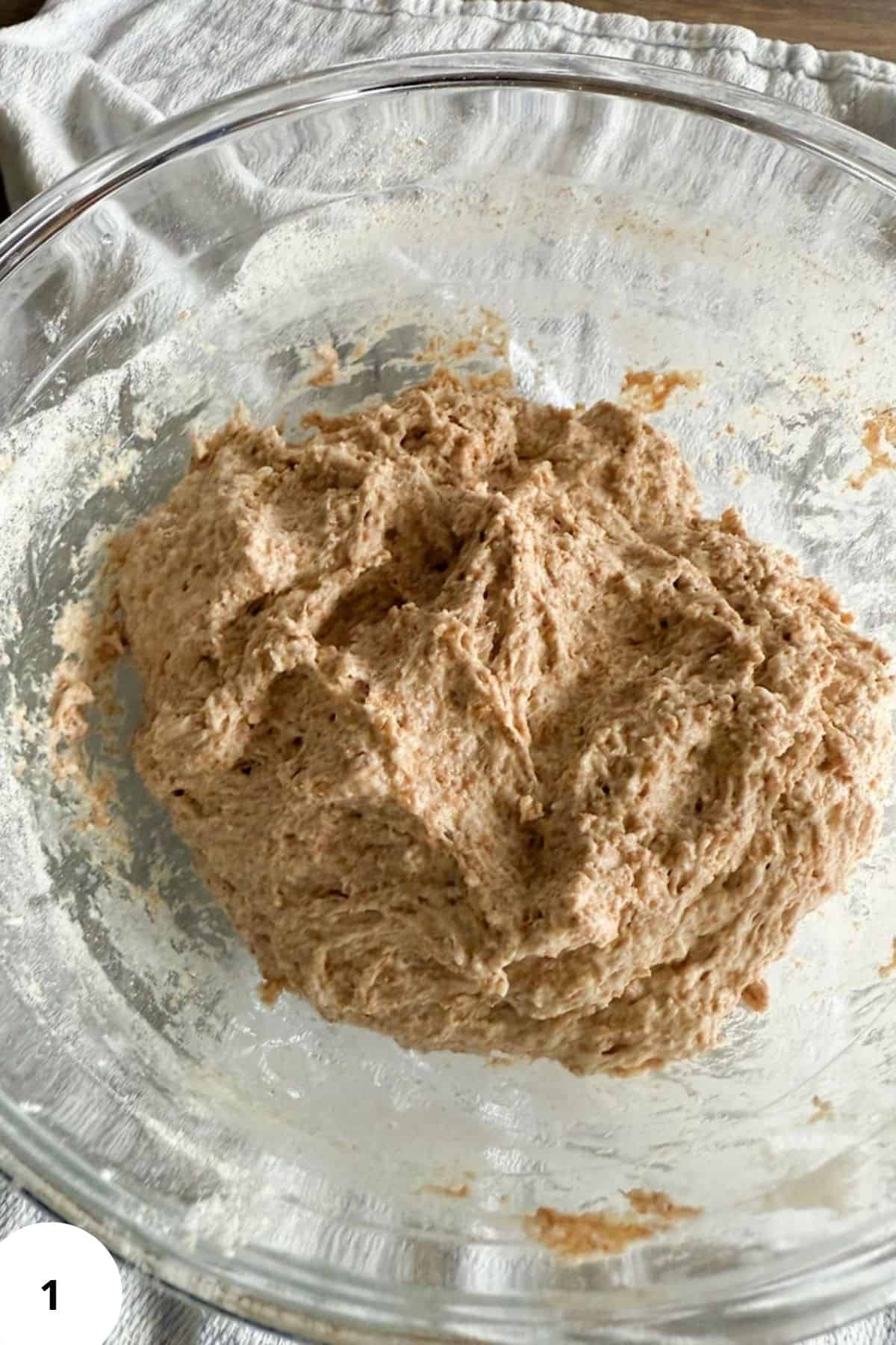Fresh milled whole wheat flour dough in a glass bowl, ready for baking or cooking.