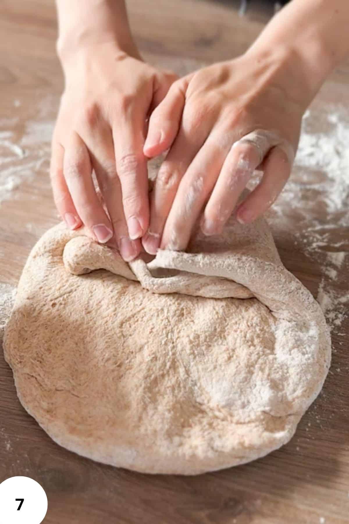 Hand kneading freshly ground flour dough for bread.
