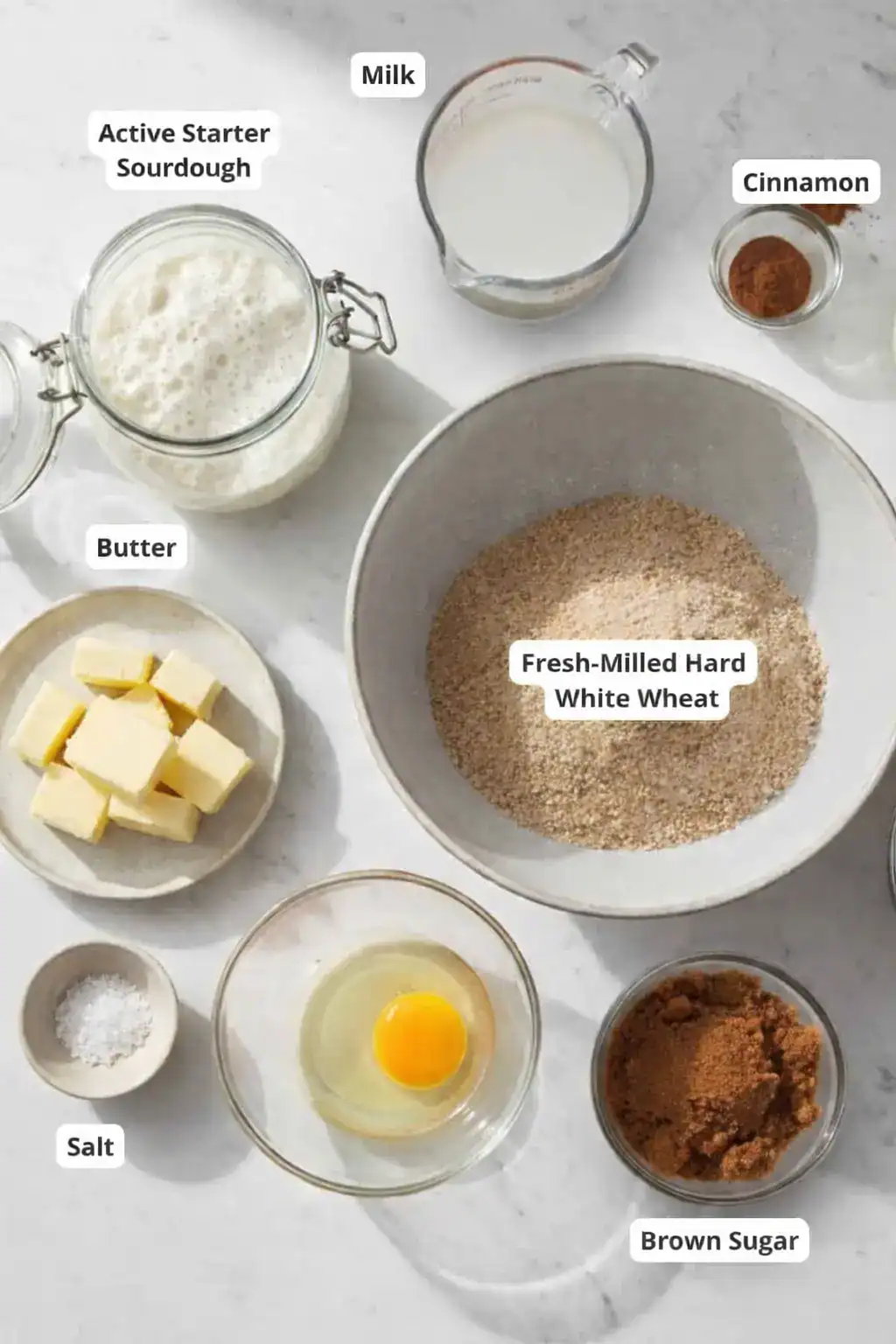 Ingredients for whole grain sourdough cinnamon rolls with fresh milled wheat, butter, milk, cinnamon.