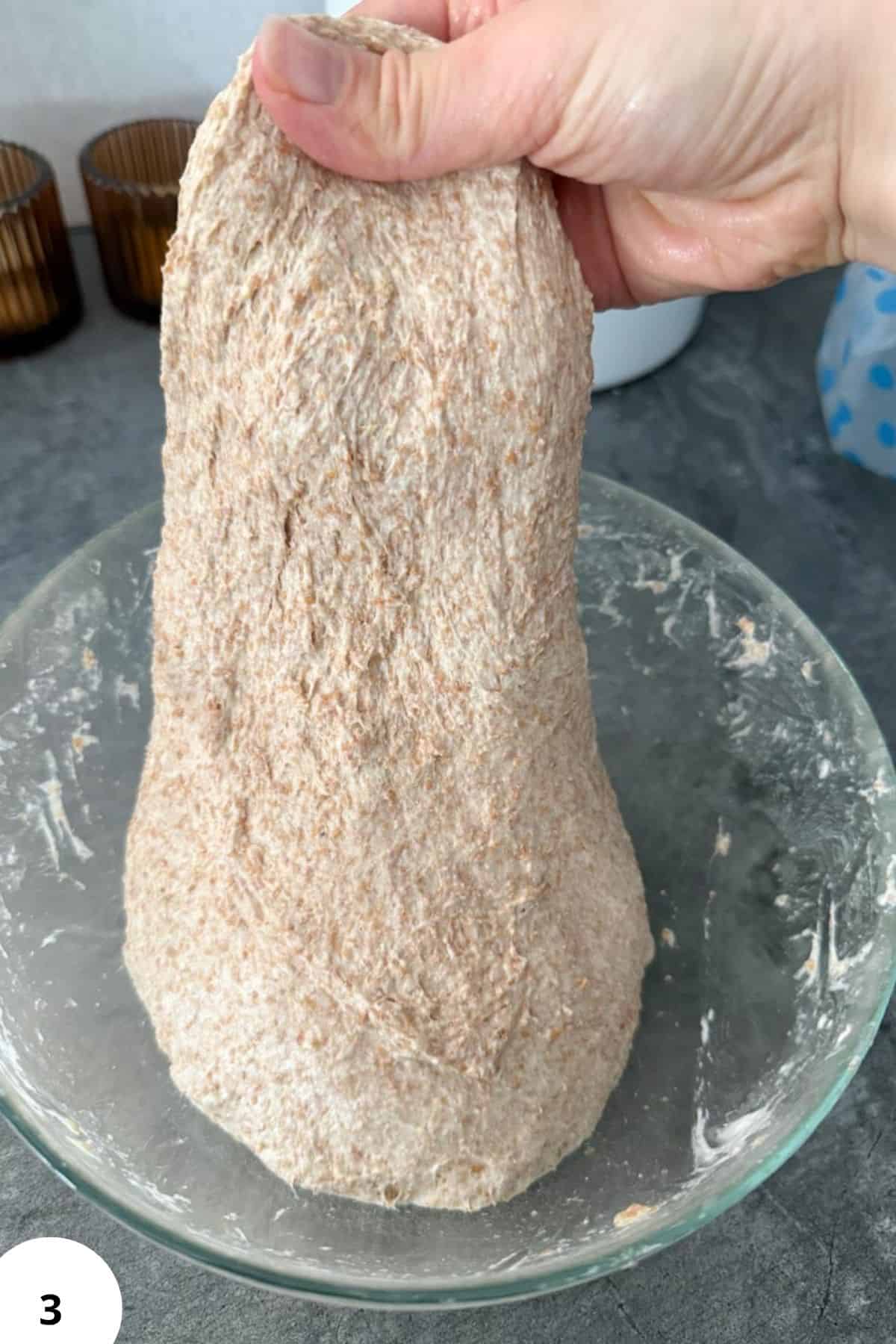 Hand holding freshly milled grain for healthy baking, homemade flour, and nutritious recipes.