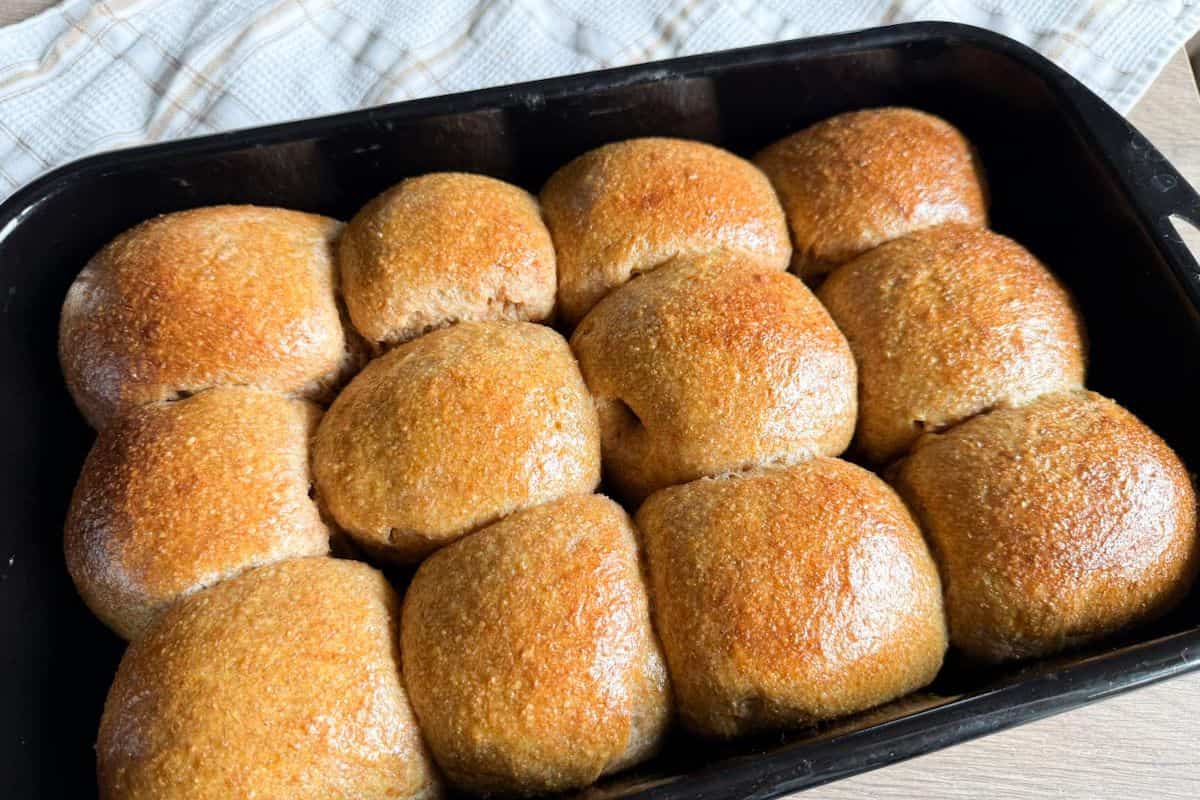 Golden crust homemade bread rolls in a baking tray.