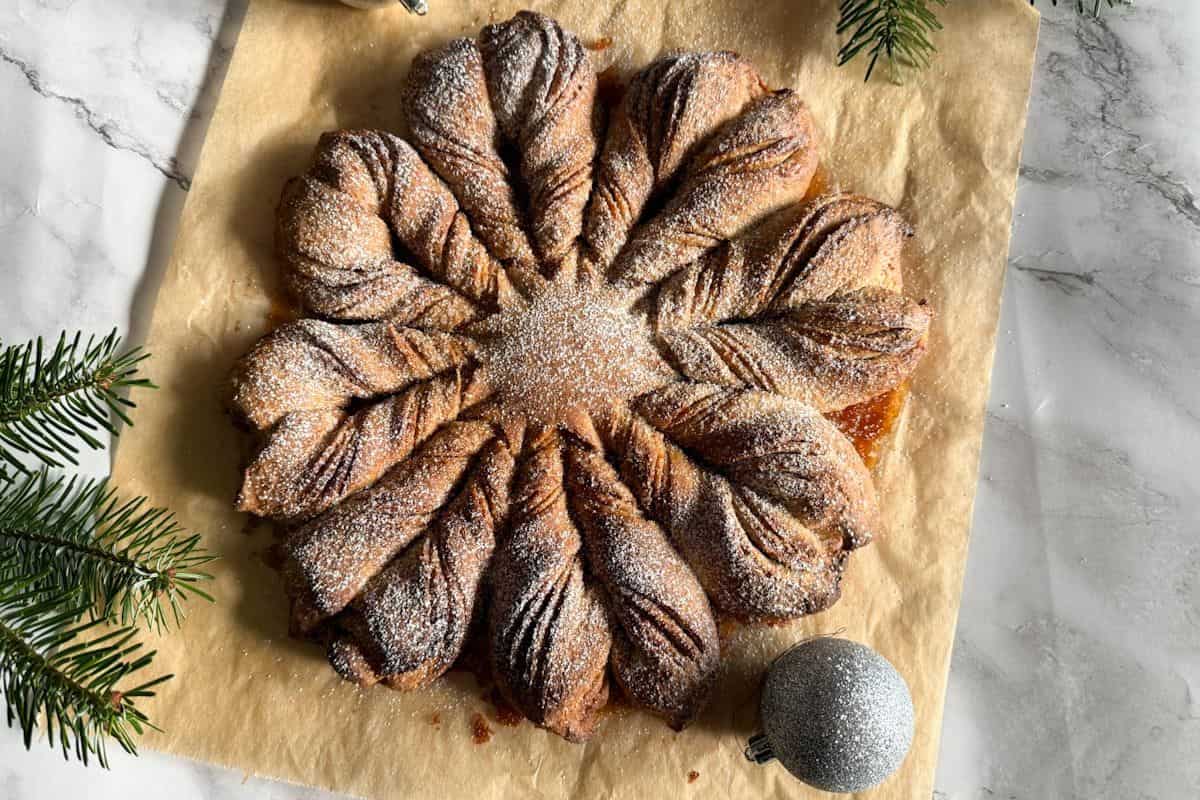 Delicious freshly baked cinnamon rolls with a decorative twist, perfect for holiday celebrations.