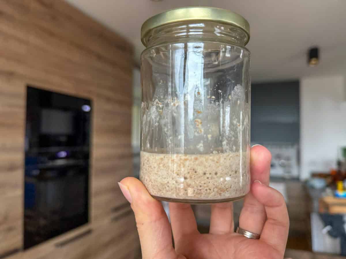 Sourdough starter in a glass jar with bubbling fermentation, made from fresh milled flour.