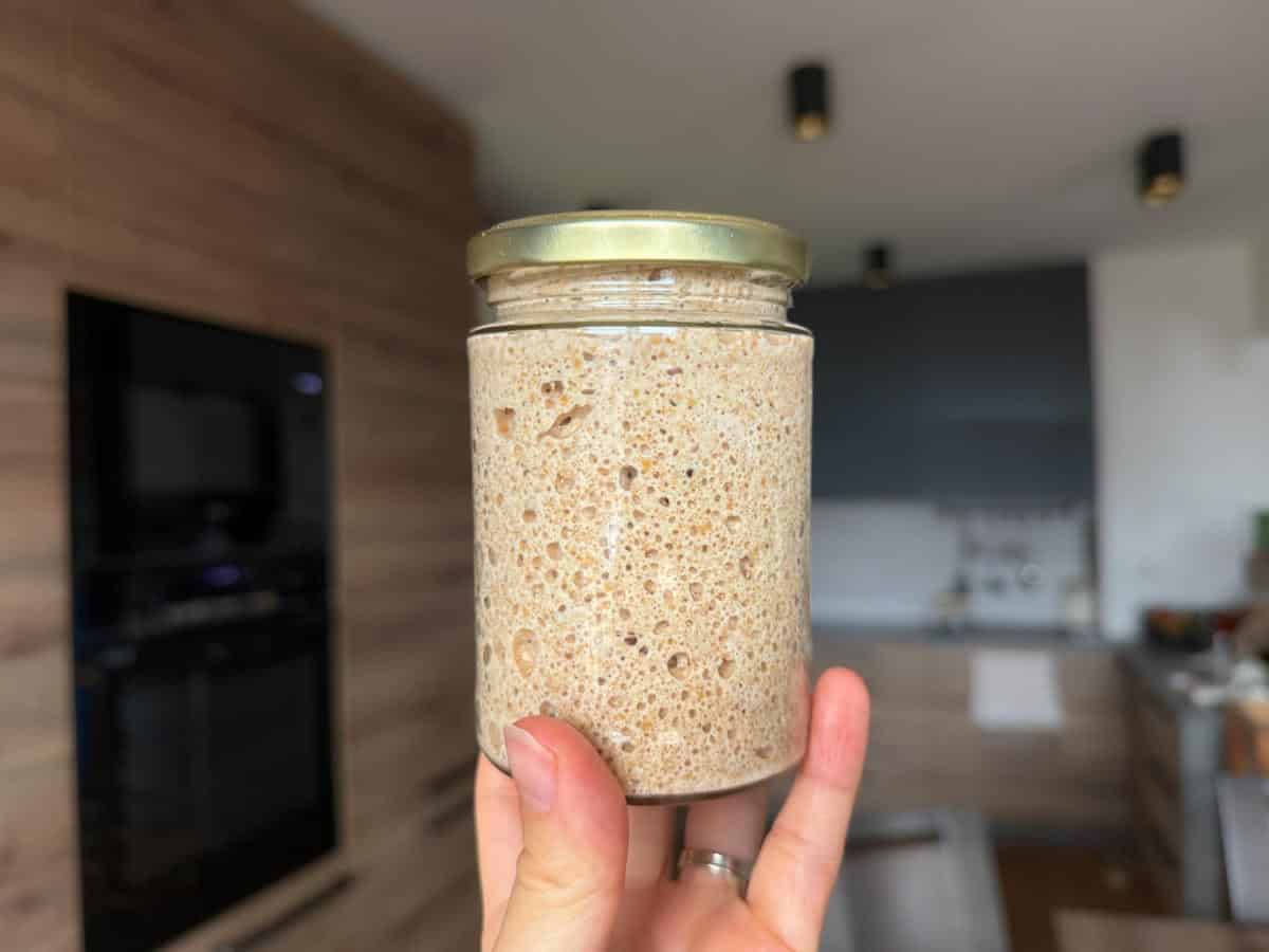 Homemade sourdough starter made with fresh milled flour in a glass jar.