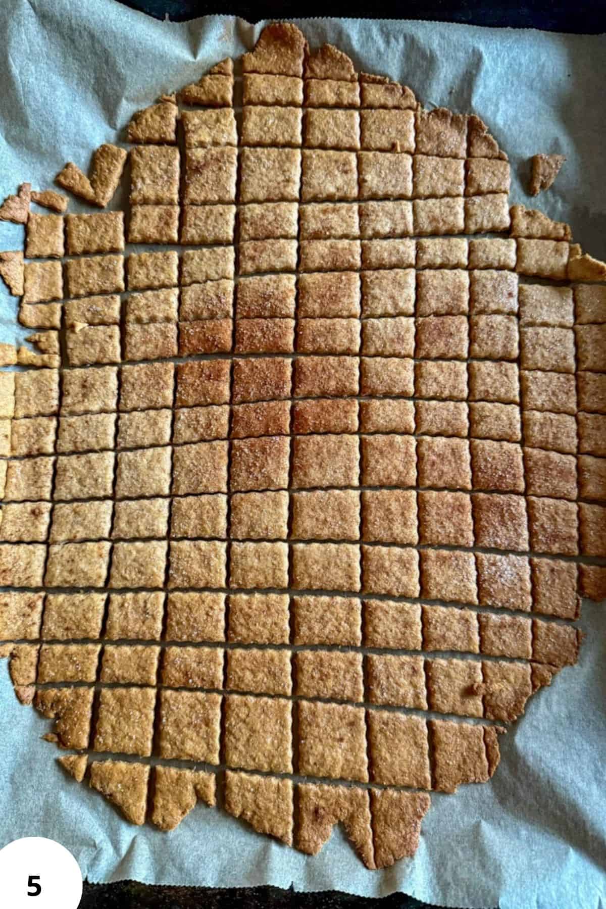 Crispy, cinnamon-flavored homemade cereal slices on parchment paper.