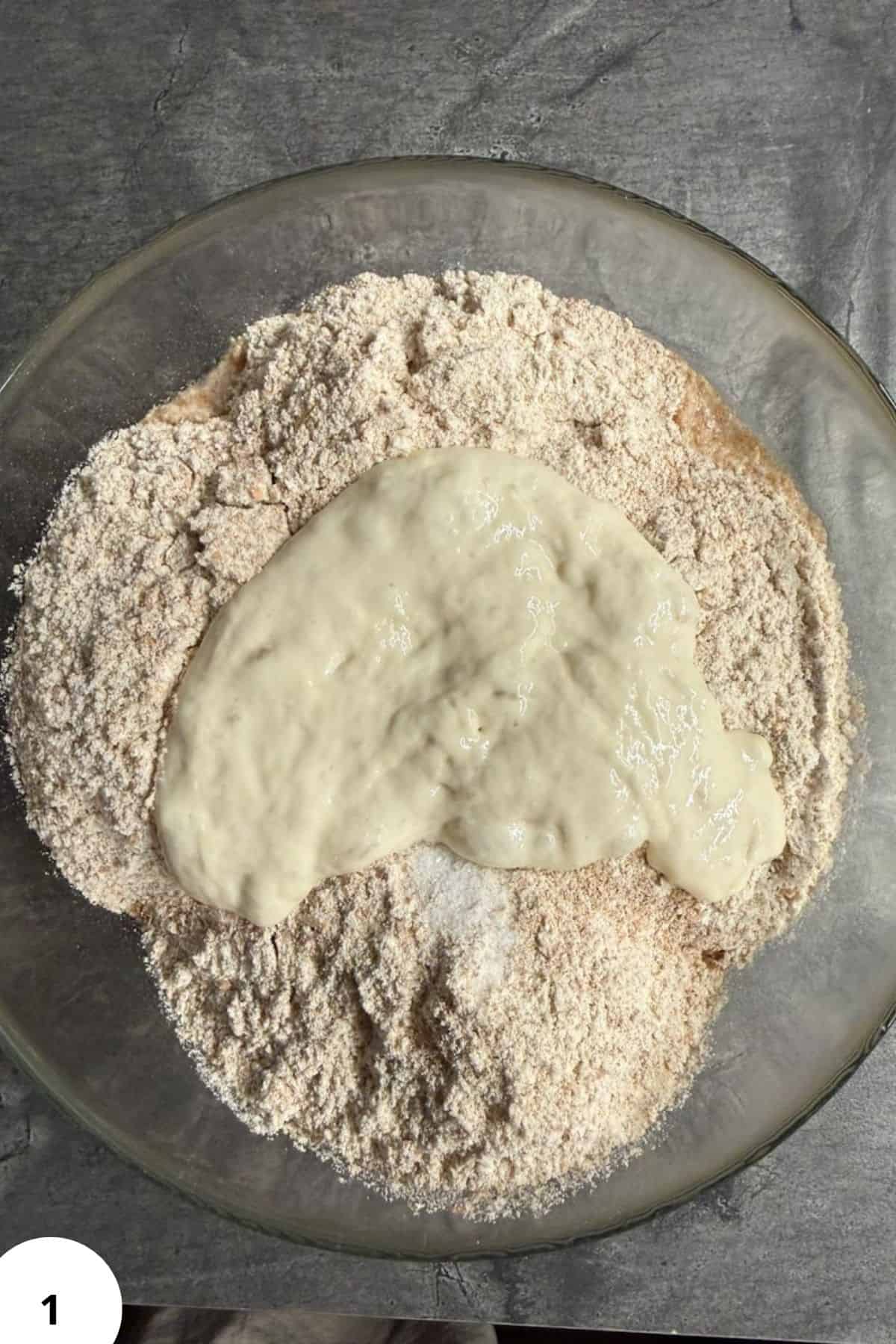Fresh milled sourdough dough with starter in a glass bowl, ready for baking.