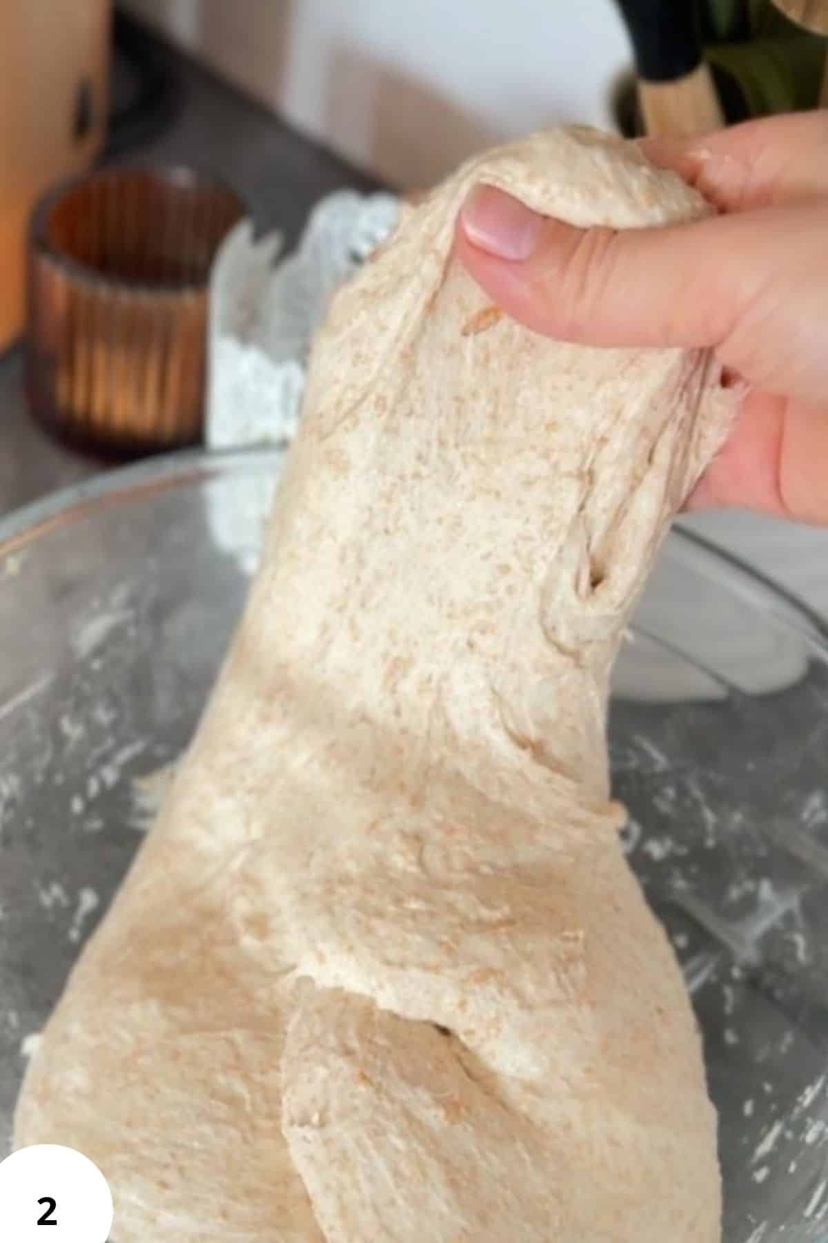 Freshly milled spelt sourdough bread roll being shaped by hand.