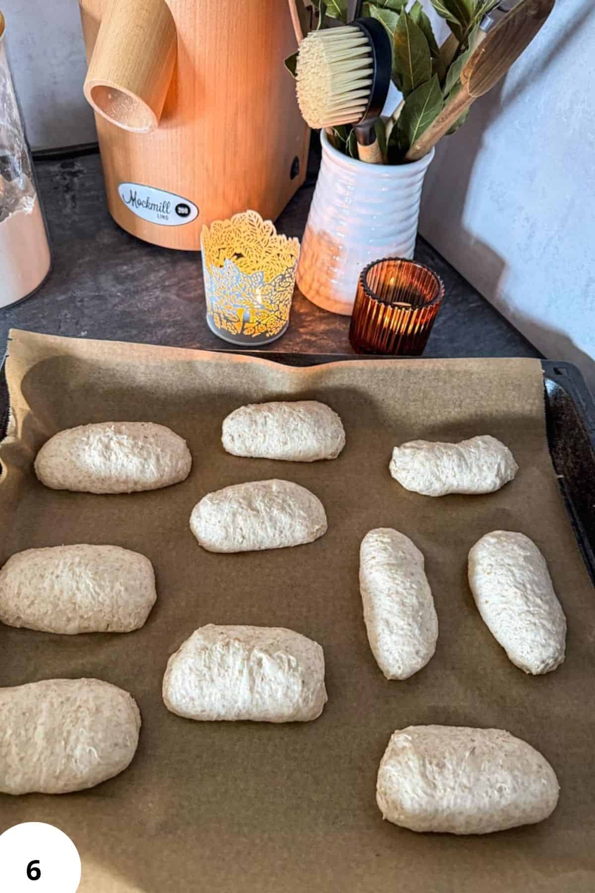 Freshly baked spelt sourdough bread rolls on a baking tray.