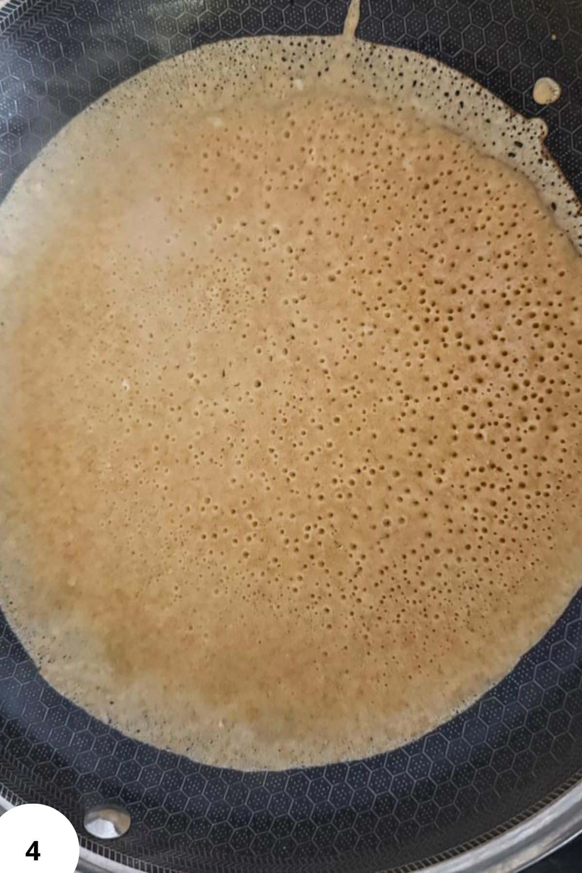 Palatschinken batter cooking in a pan for Central European crepes.