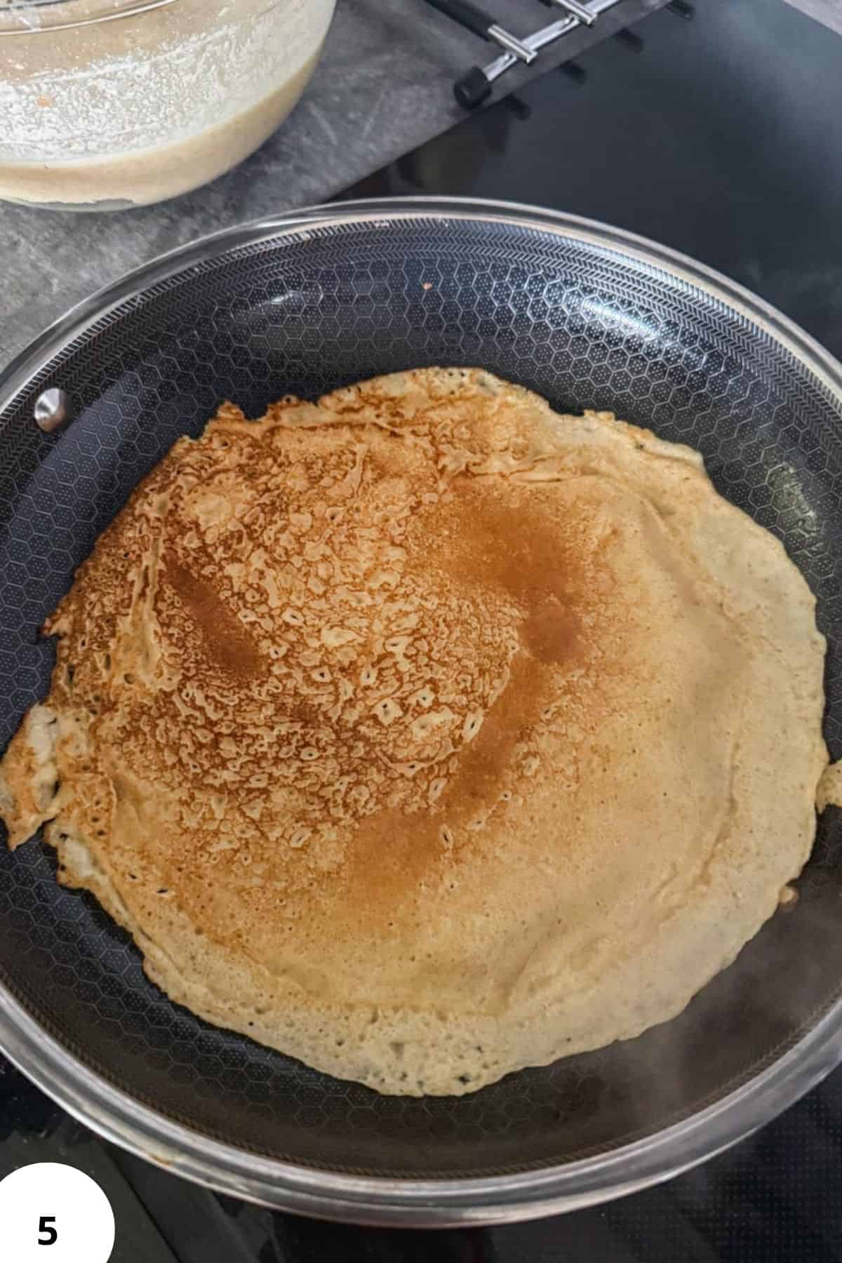 Central European crepes cooked in a non-stick pan with golden-brown edges.