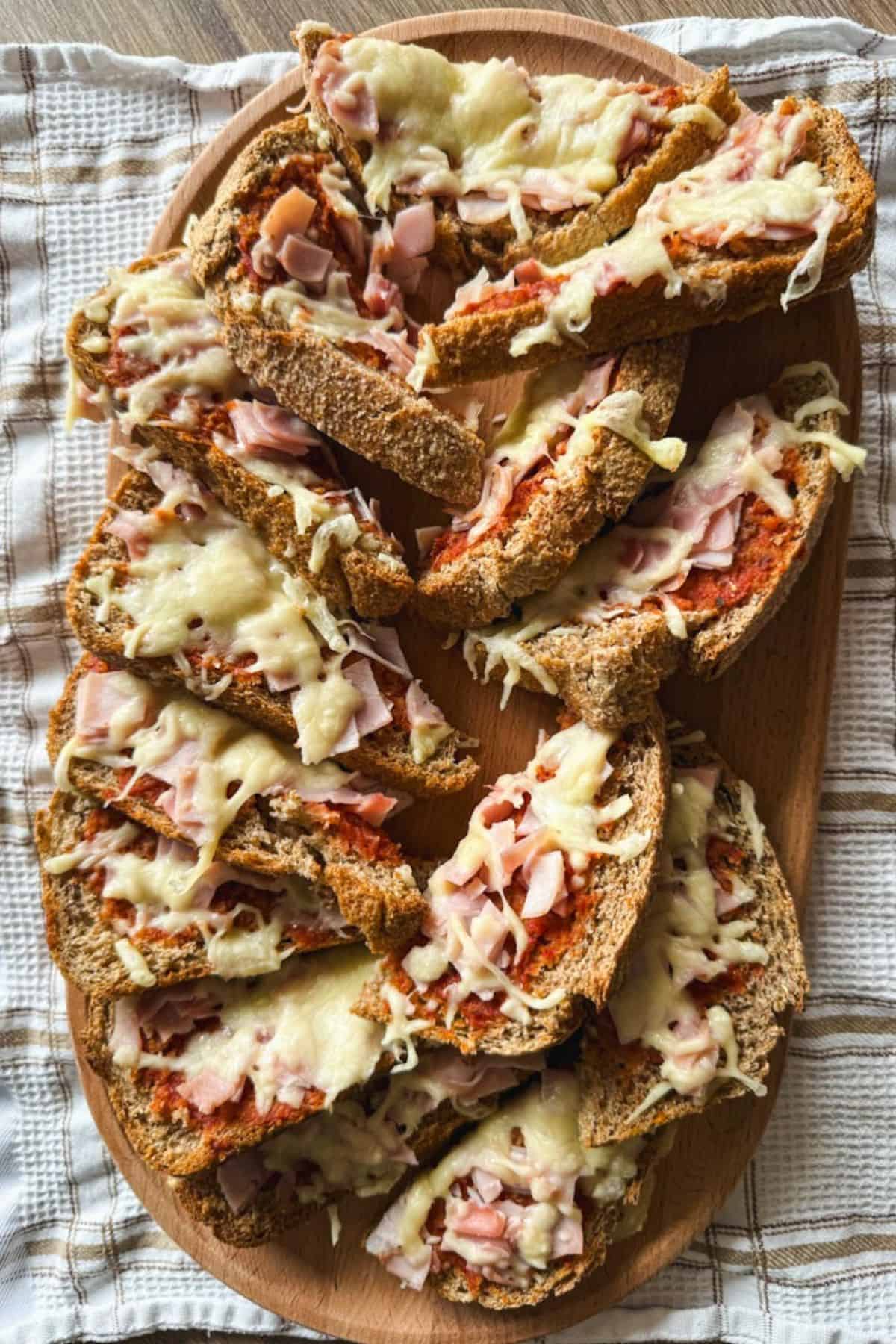 Freshly baked bread topped with melted cheese and sliced ham, perfect for a hearty snack or meal.