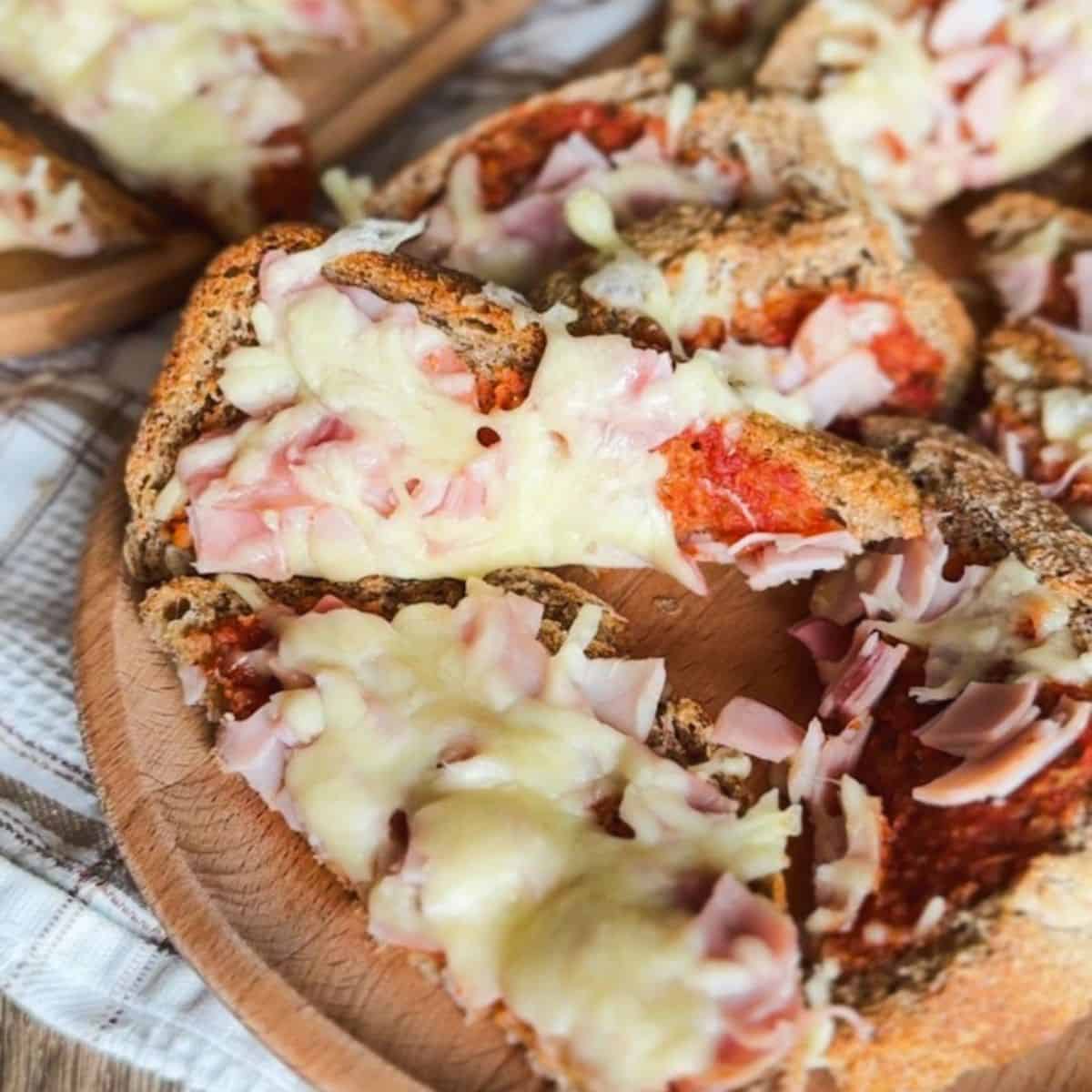 Delicious sourdough pizza toast topped with melted cheese and ham, made with freshly milled flour fo.