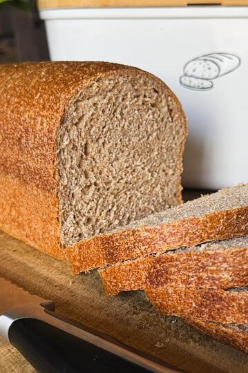 Soft, fresh-milled sourdough sandwich bread sliced on a wooden board.