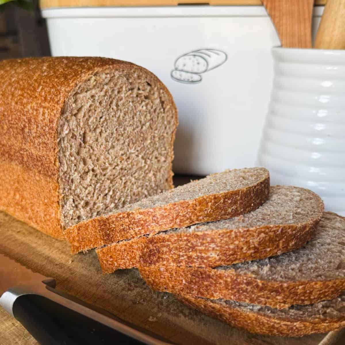 Soft, fresh-milled sourdough sandwich bread sliced on a wooden board.