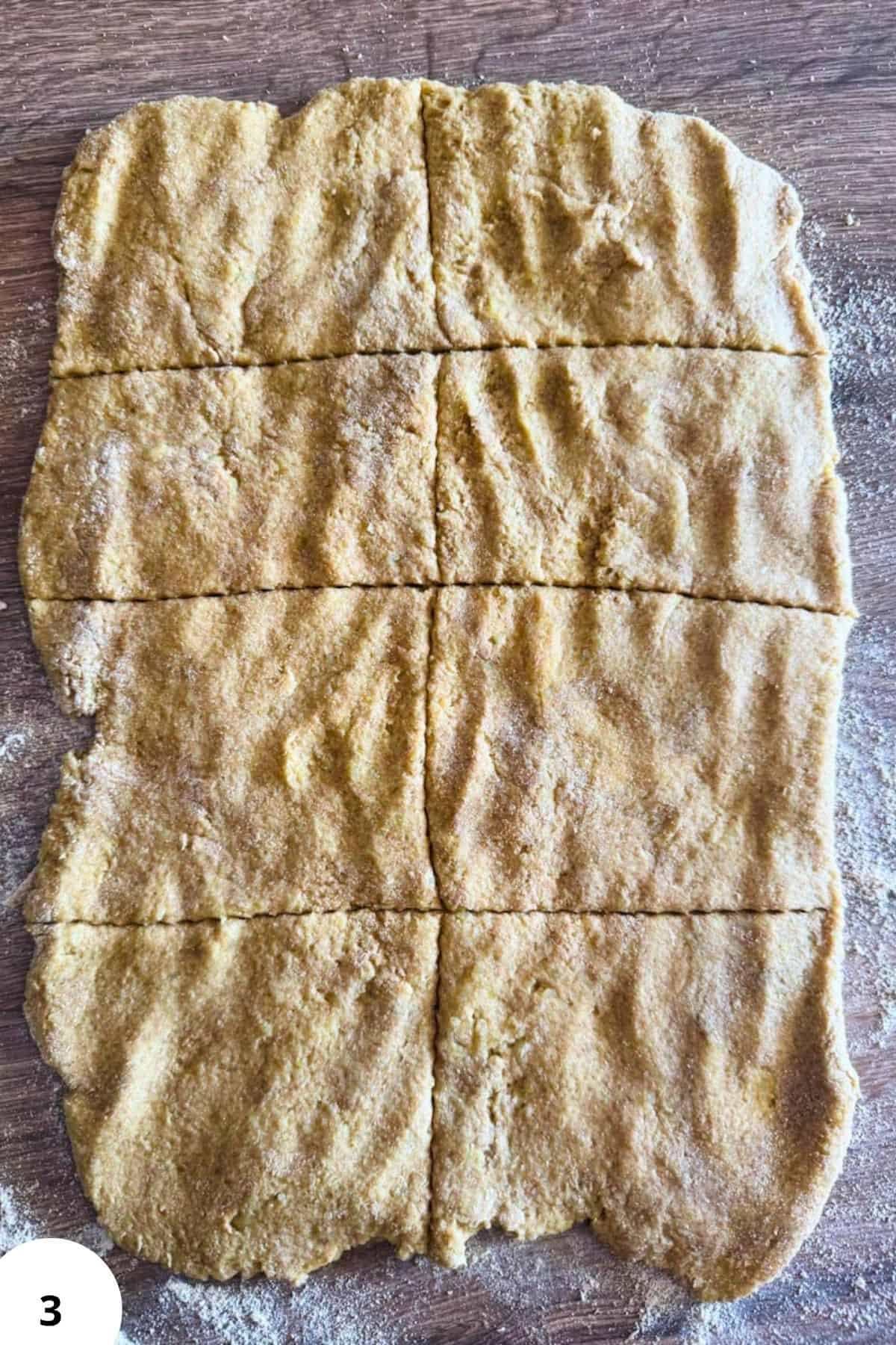 Freshly baked cornbread made with freshly milled corn, sliced into pieces on a rustic wooden surface.