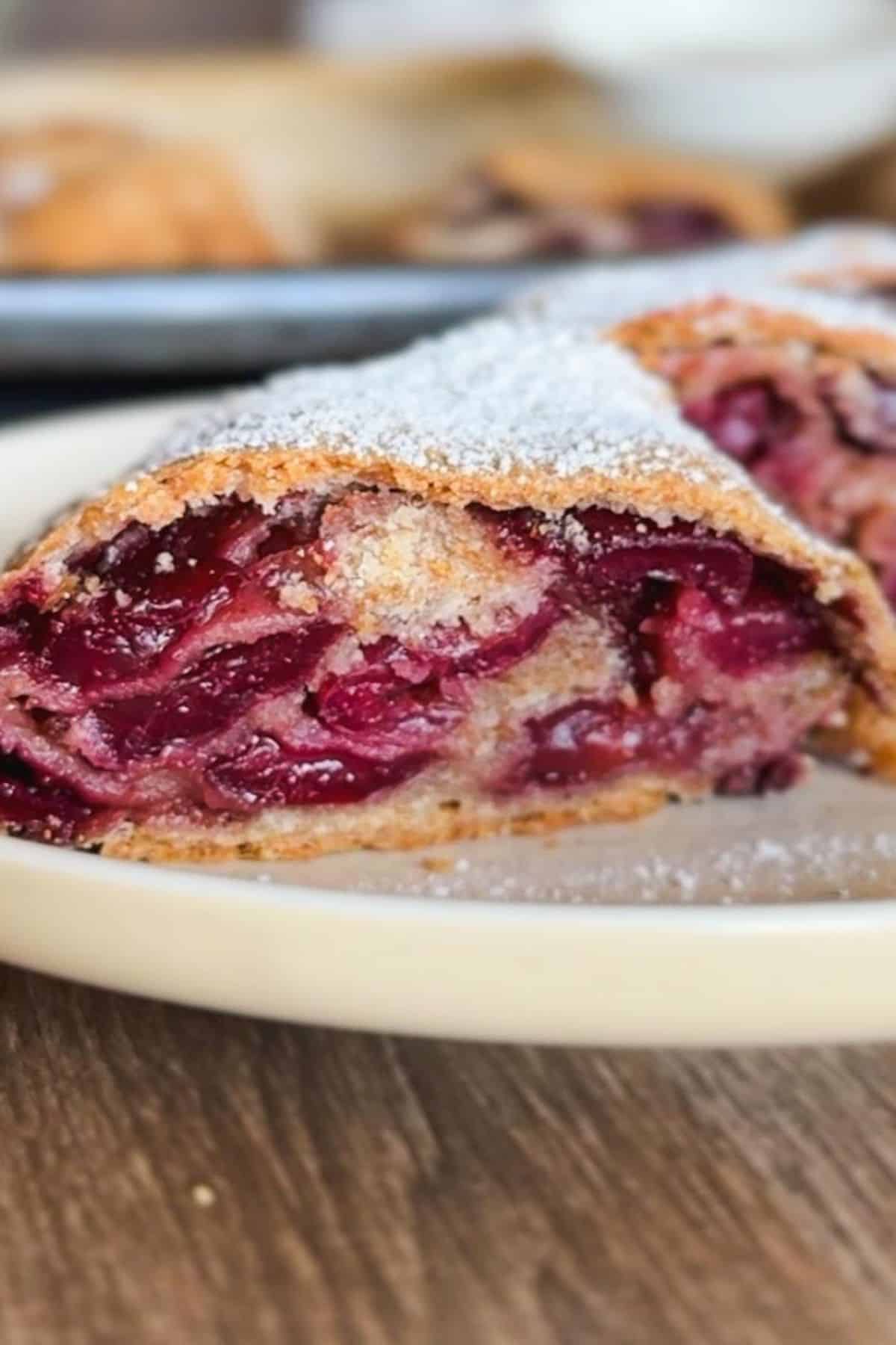 Cherry strudel with powdered sugar on top, fresh and delicious.