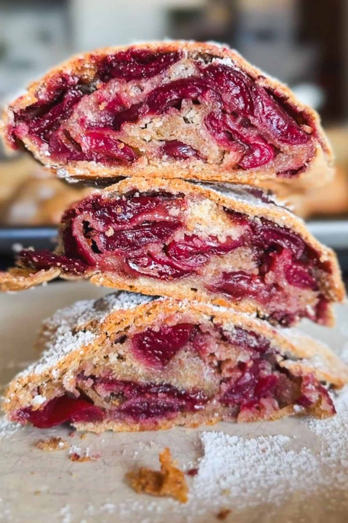 Close-up of cherry strudel with flaky crust and cherry filling.