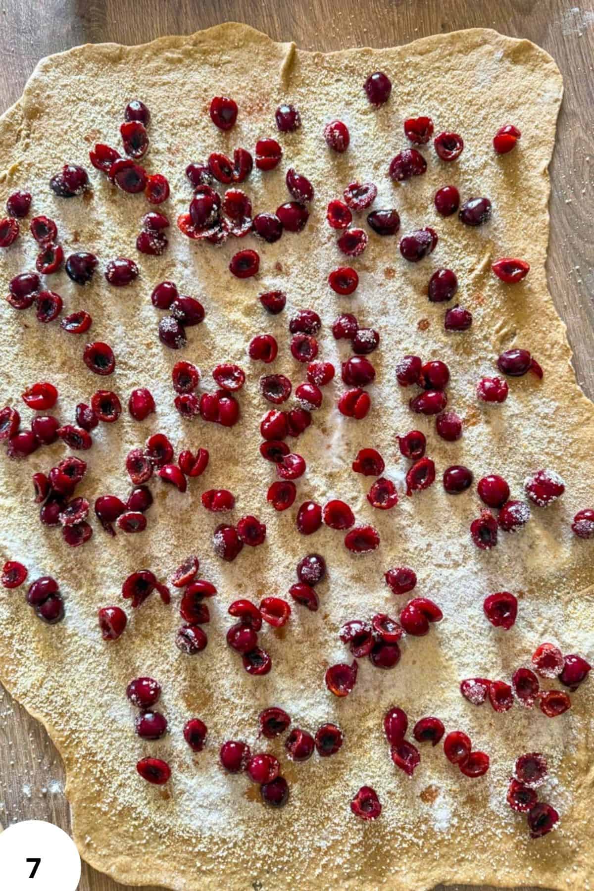 Cherry filling on rolled dough for cherry strudel.