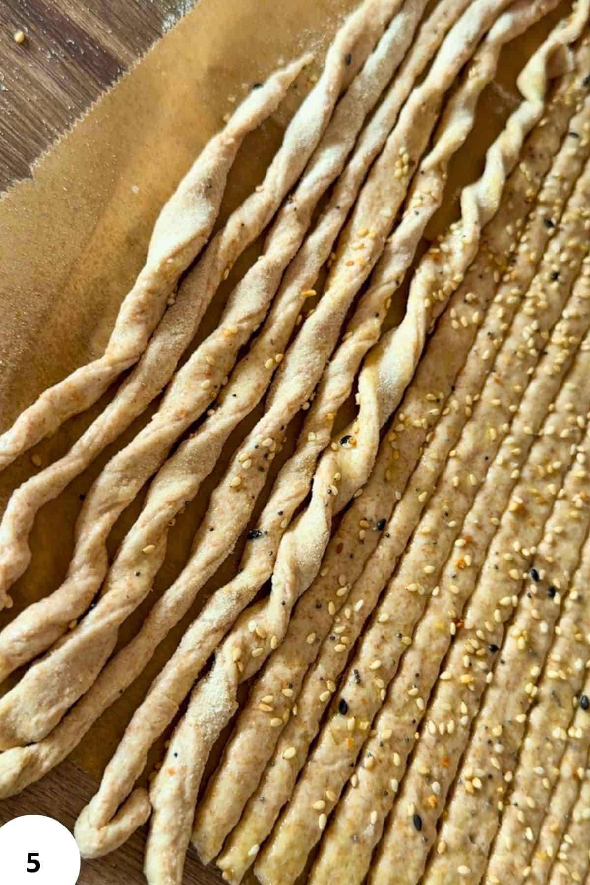 Homemade breadsticks and crackers made from freshly milled grains on a baking sheet.