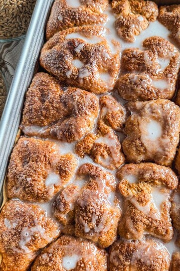 Close-up of cinnamon roll pull-apart focaccia with glaze and cinnamon sugar topping.