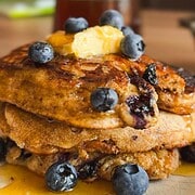 Stack of sourdough pancakes topped with blueberries and butter.